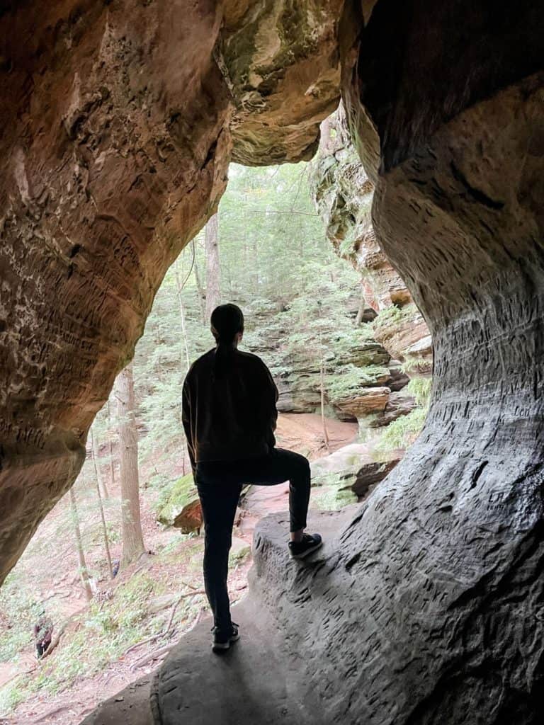 Woman standing while looking out of a window in Rock House