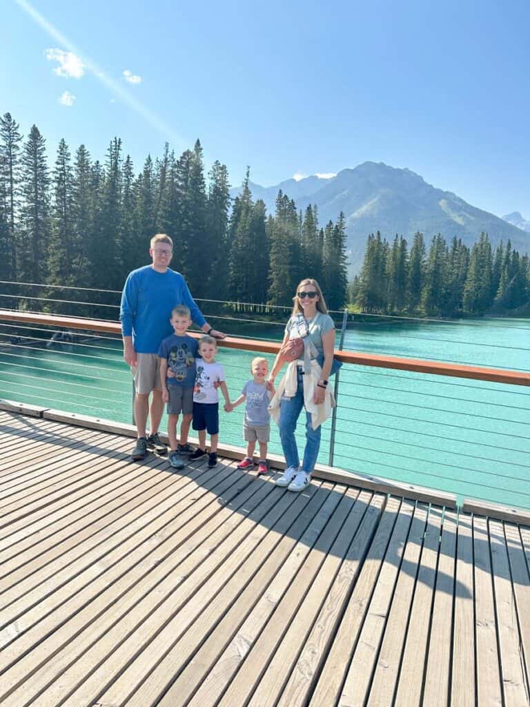 Family on pedestrian bridge over Bow River in Banff with kids