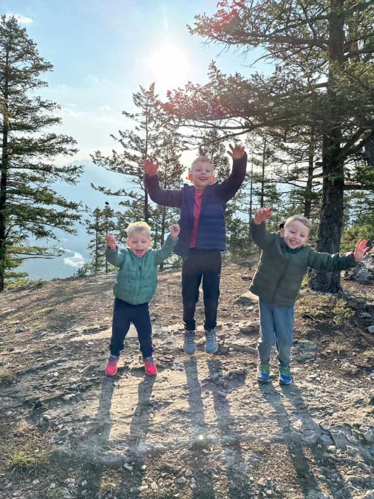 3 boys jumping after hiking Tunnel Mountain, kid-friendly hike in Banff