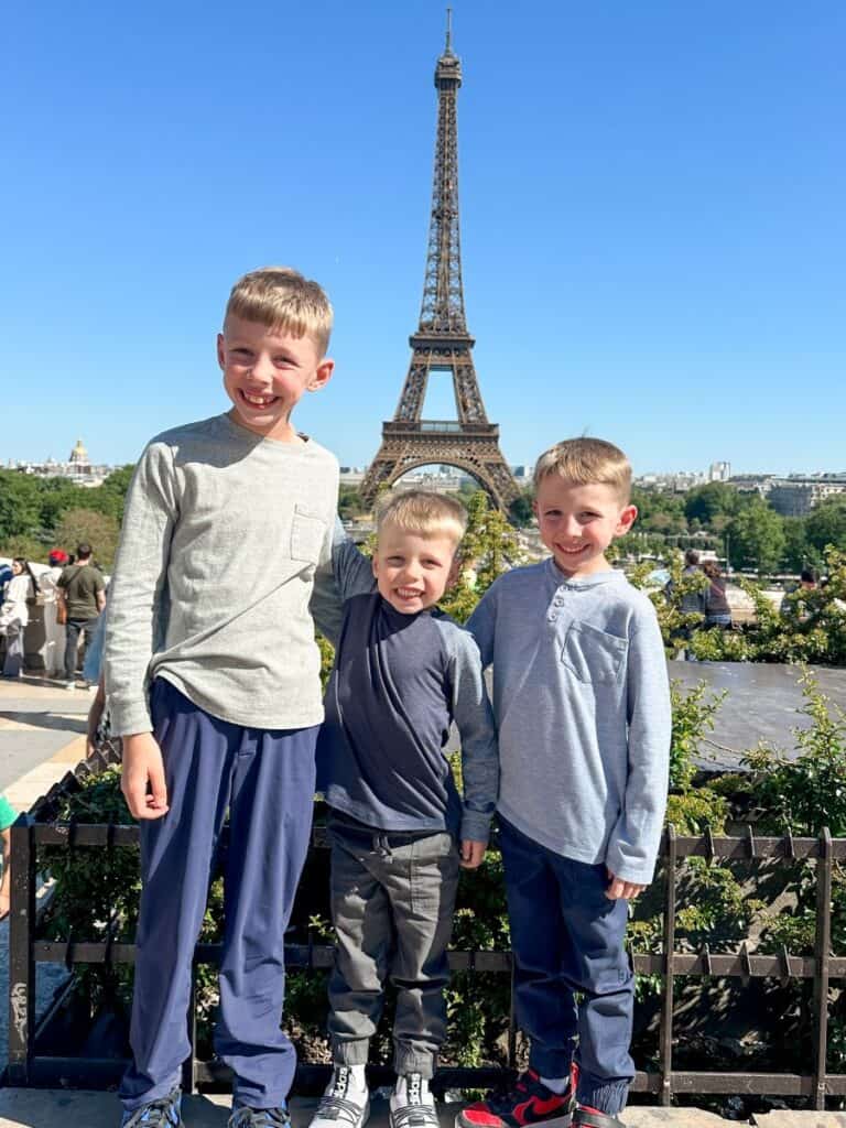 Kids enjoying a family trip to Paris with the Eiffel Tower in the background, capturing a memorable travel moment.